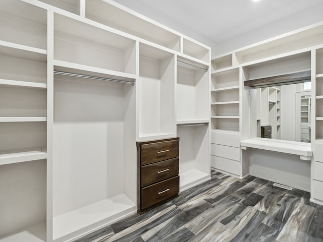 spacious closet featuring dark hardwood / wood-style flooring