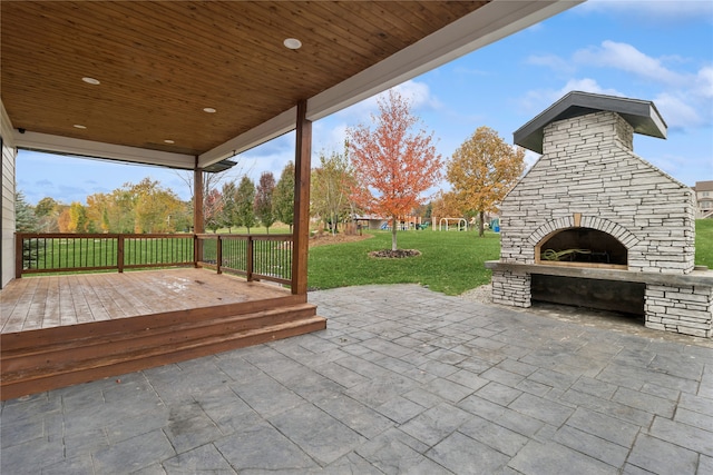 view of patio featuring an outdoor stone fireplace and a wooden deck