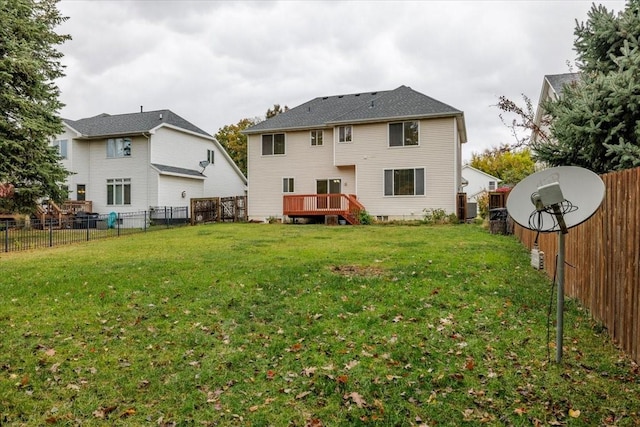 rear view of house with a yard and a deck