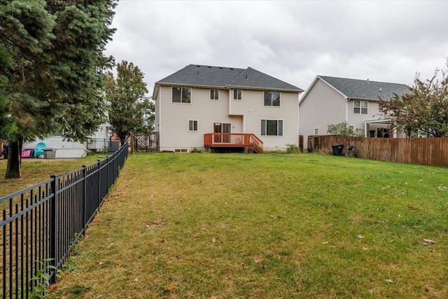 back of property featuring a lawn and a wooden deck