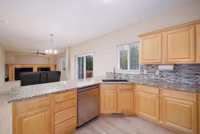 kitchen featuring sink, dishwasher, light brown cabinets, tasteful backsplash, and light hardwood / wood-style flooring