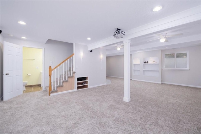 basement featuring light carpet and ceiling fan