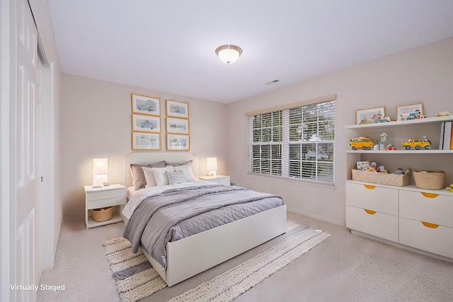 bedroom with light colored carpet and a closet