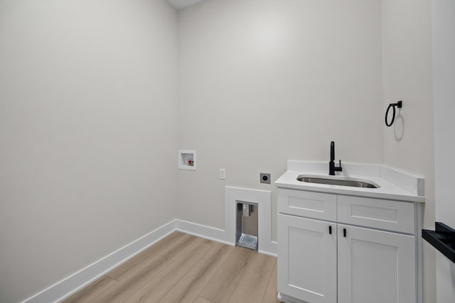 laundry room featuring baseboards, hookup for a washing machine, hookup for an electric dryer, light wood-type flooring, and a sink