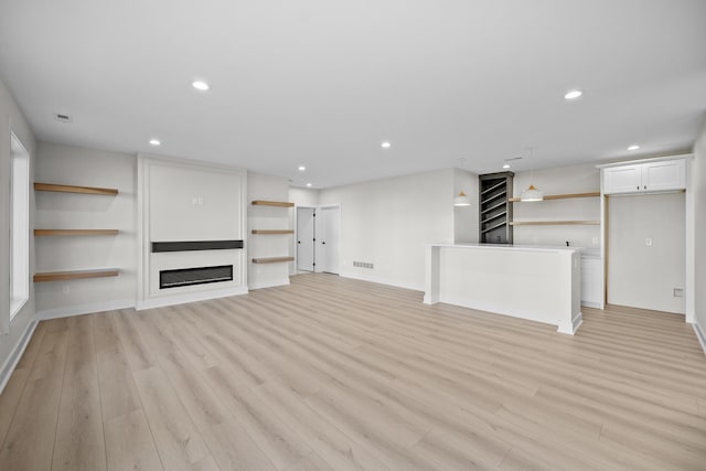 unfurnished living room featuring recessed lighting, a large fireplace, visible vents, and light wood-style flooring