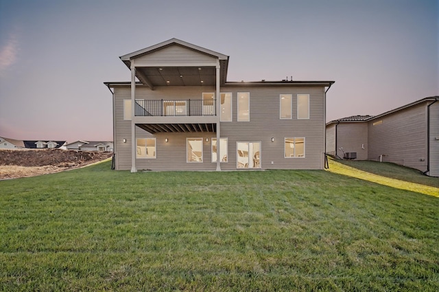 rear view of property featuring a lawn