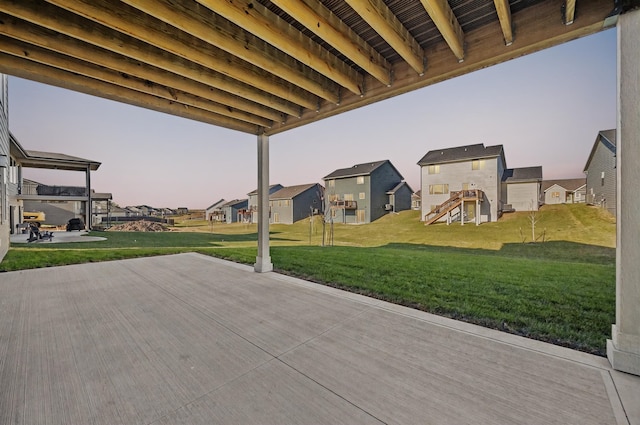 patio terrace at dusk with a residential view and a lawn