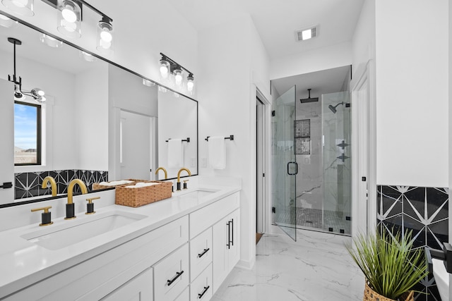 bathroom featuring a shower with door and vanity