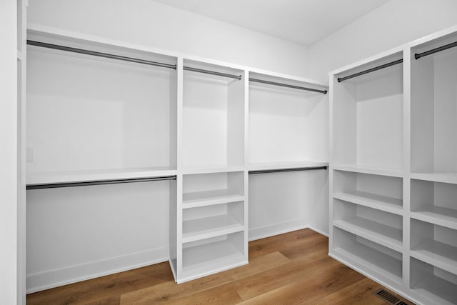 walk in closet with hardwood / wood-style flooring