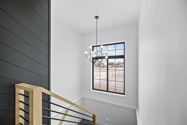 stairs featuring plenty of natural light and a notable chandelier