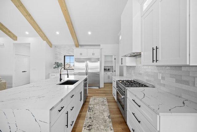 kitchen featuring high quality appliances, premium range hood, a center island with sink, sink, and beam ceiling