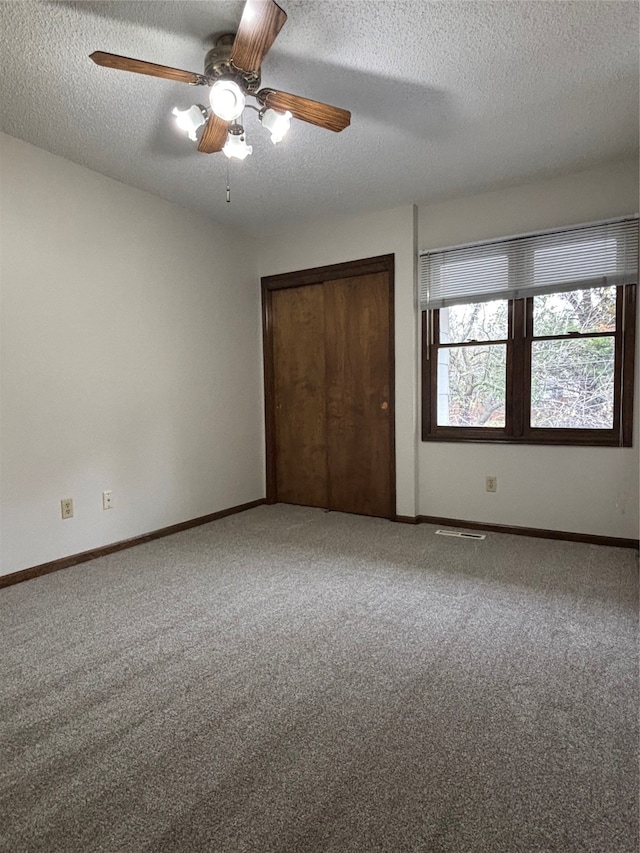 unfurnished bedroom featuring a textured ceiling, ceiling fan, and carpet floors