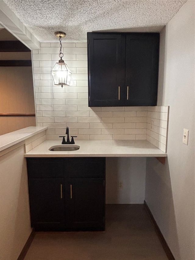 interior space with tasteful backsplash, decorative light fixtures, sink, and a textured ceiling