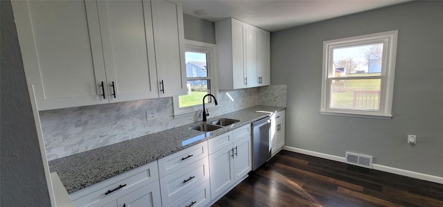 kitchen with stainless steel dishwasher, sink, a healthy amount of sunlight, and white cabinets