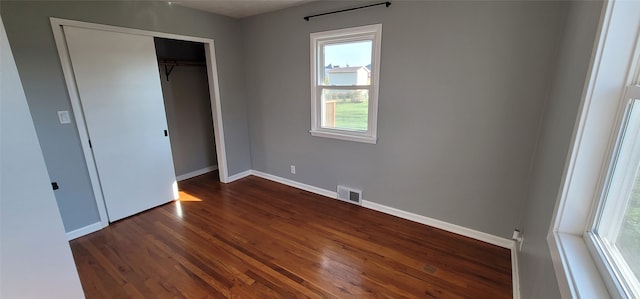 unfurnished bedroom featuring dark hardwood / wood-style floors and a closet