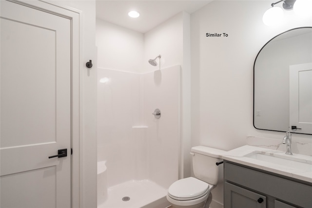 bathroom with vanity, toilet, and a shower