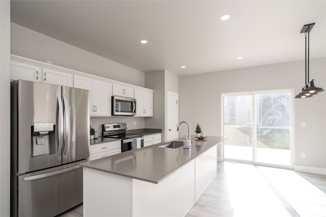 kitchen featuring white cabinets, an island with sink, stainless steel appliances, and sink