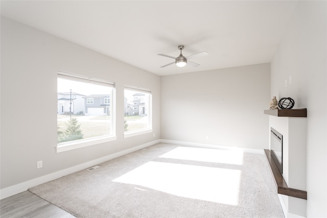 unfurnished living room featuring hardwood / wood-style flooring and ceiling fan