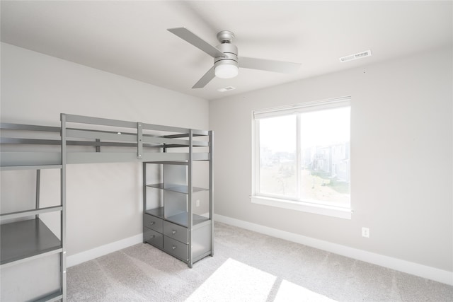 unfurnished bedroom with ceiling fan and light colored carpet