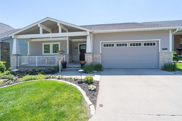 1902 Park Ave, Des Moines, IA 50315 - craftsman house featuring stone siding, a garage, concrete driveway, a porch, and a shingled roof