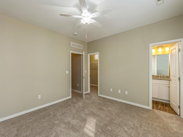 313 SW 7th St Unit 107, Des Moines, IA 50309 - unfurnished bedroom featuring carpet, a spacious closet, baseboards, and ensuite bathroom