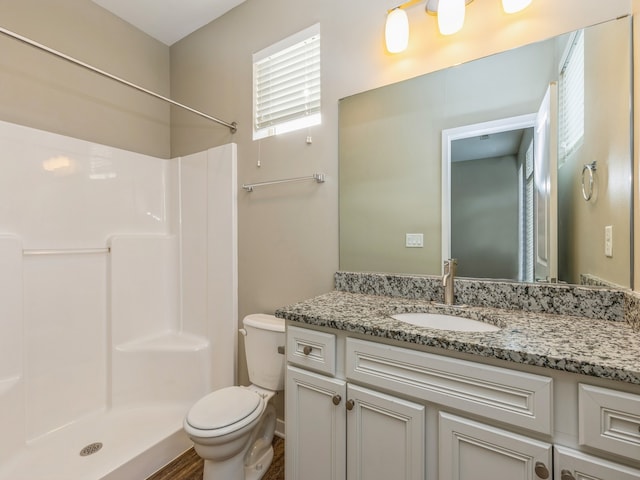 bathroom with walk in shower, vanity, toilet, and wood-type flooring