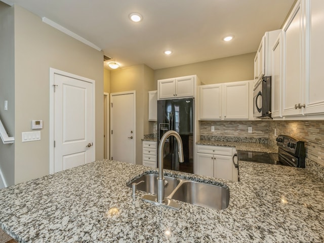 kitchen featuring white cabinetry, sink, black appliances, kitchen peninsula, and light stone countertops