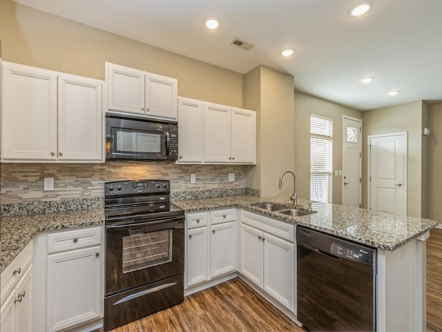 kitchen featuring black appliances, kitchen peninsula, sink, and white cabinets