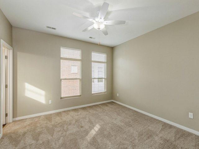 empty room with ceiling fan and light colored carpet