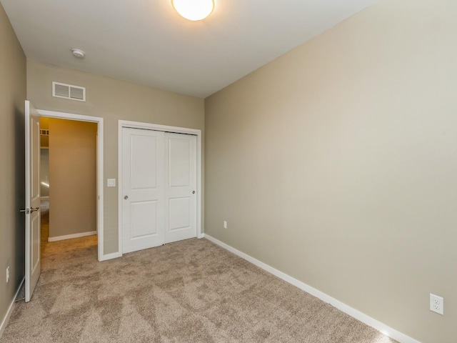 313 SW 7th St Unit 107, Des Moines, IA 50309 - unfurnished bedroom with carpet floors, baseboards, and a closet