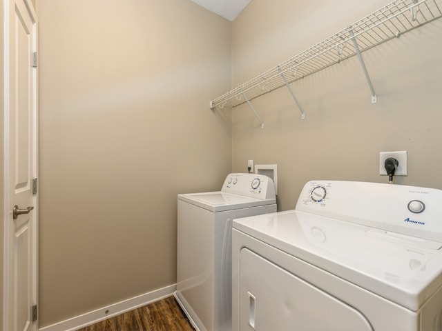 laundry area with dark hardwood / wood-style flooring and washer and dryer