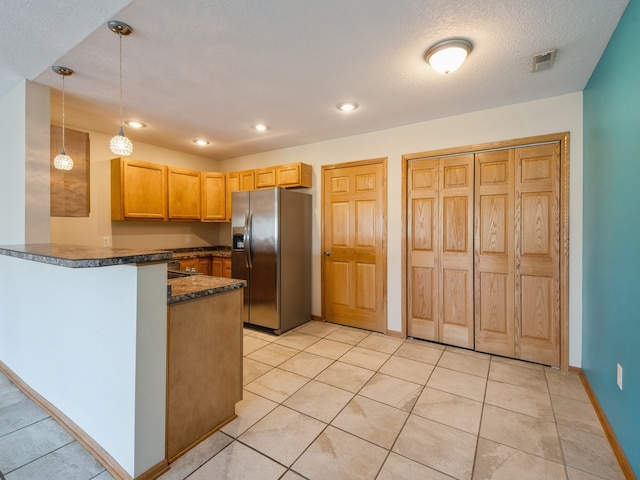 kitchen with decorative light fixtures, stainless steel fridge with ice dispenser, light tile patterned floors, a textured ceiling, and kitchen peninsula