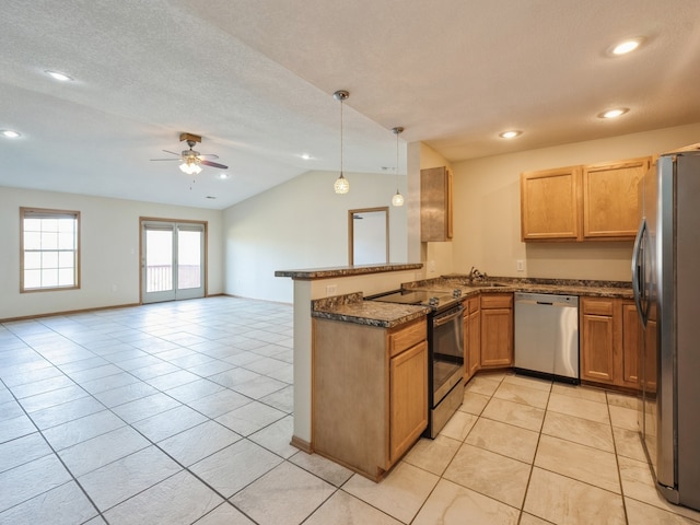 kitchen with vaulted ceiling, kitchen peninsula, hanging light fixtures, ceiling fan, and appliances with stainless steel finishes