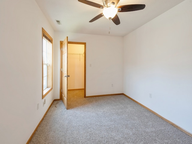 spare room featuring carpet, plenty of natural light, and ceiling fan