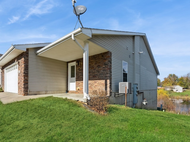 view of front of property featuring a garage, cooling unit, and a front yard