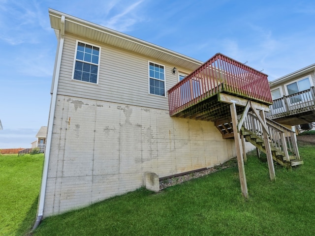 back of property with a yard and a wooden deck