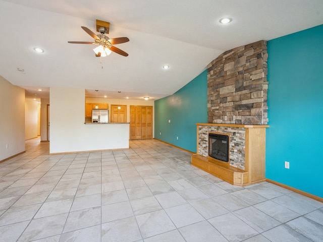 unfurnished living room featuring a fireplace, lofted ceiling, ceiling fan, and light tile patterned floors