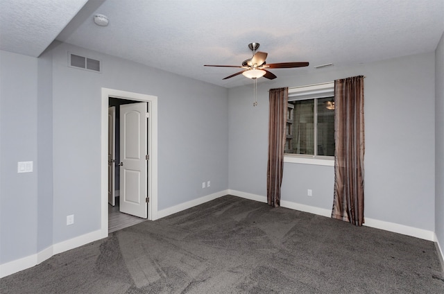 carpeted empty room featuring ceiling fan and a textured ceiling