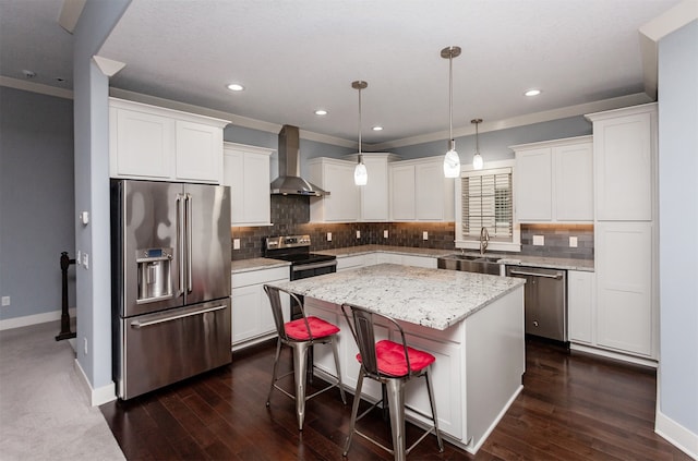 kitchen with stainless steel appliances, dark wood-type flooring, a center island, wall chimney exhaust hood, and pendant lighting