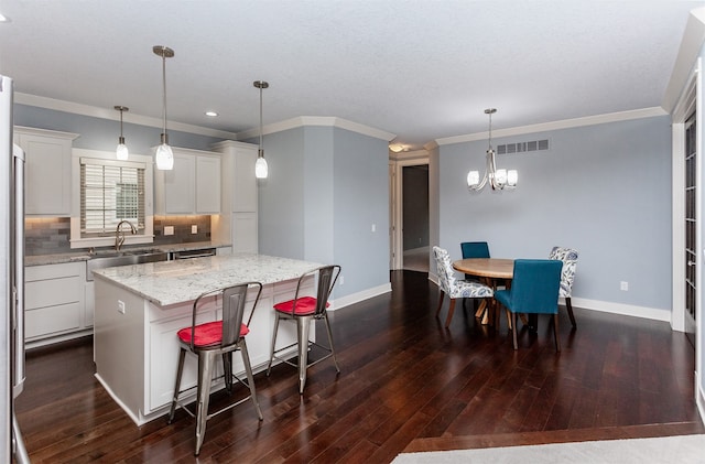 kitchen with white cabinets, pendant lighting, dark hardwood / wood-style floors, and a kitchen island