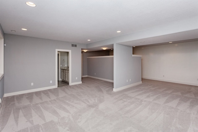 basement featuring light carpet