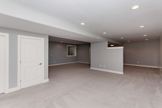 basement featuring a textured ceiling and light carpet