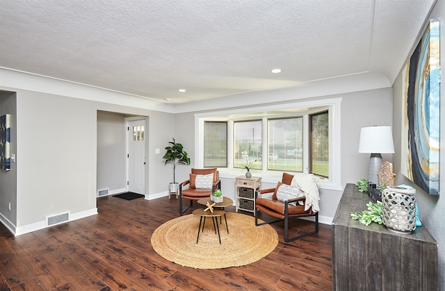 living area featuring dark hardwood / wood-style floors and a textured ceiling