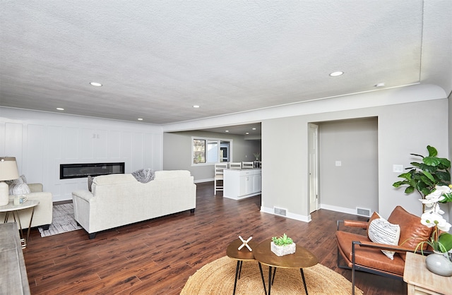 living room with dark wood-type flooring and a textured ceiling