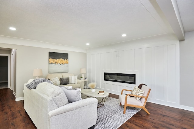 living room featuring dark wood-type flooring and a textured ceiling