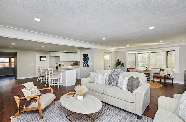 living room with a healthy amount of sunlight, dark hardwood / wood-style flooring, and a textured ceiling