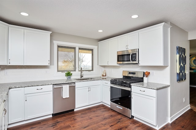 kitchen with white cabinetry, sink, stainless steel appliances, and dark hardwood / wood-style floors