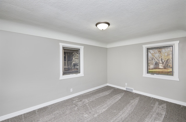 spare room with a textured ceiling and carpet floors