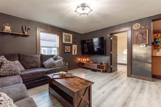 living room with light hardwood / wood-style floors and a textured ceiling