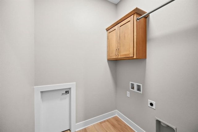 washroom with cabinets, light hardwood / wood-style floors, hookup for a washing machine, and electric dryer hookup